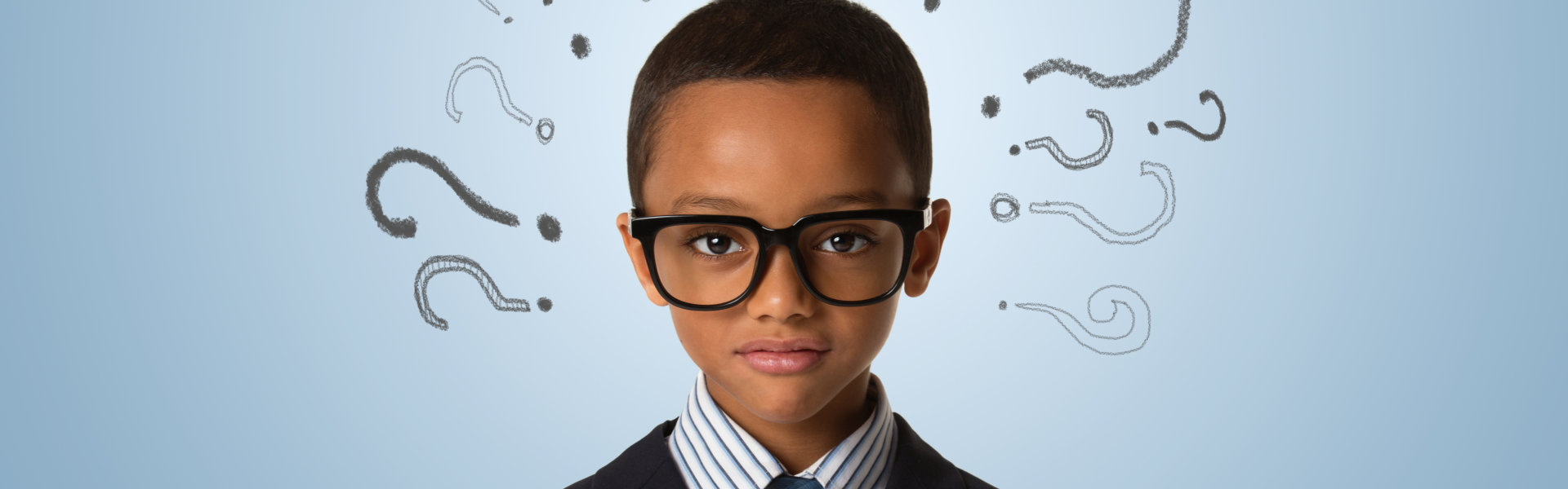 A young boy wearing eye glass