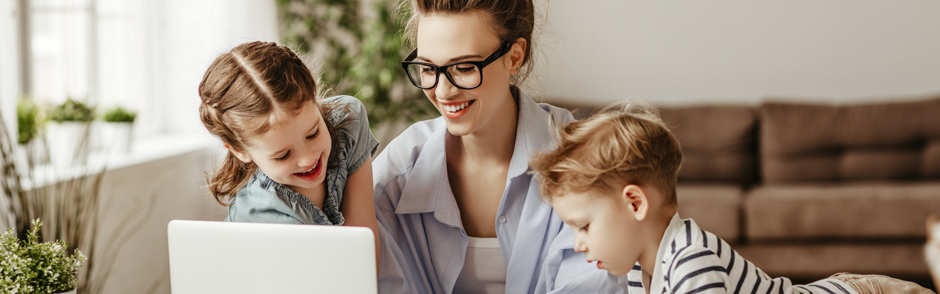 A woman and two children looking at the laptop